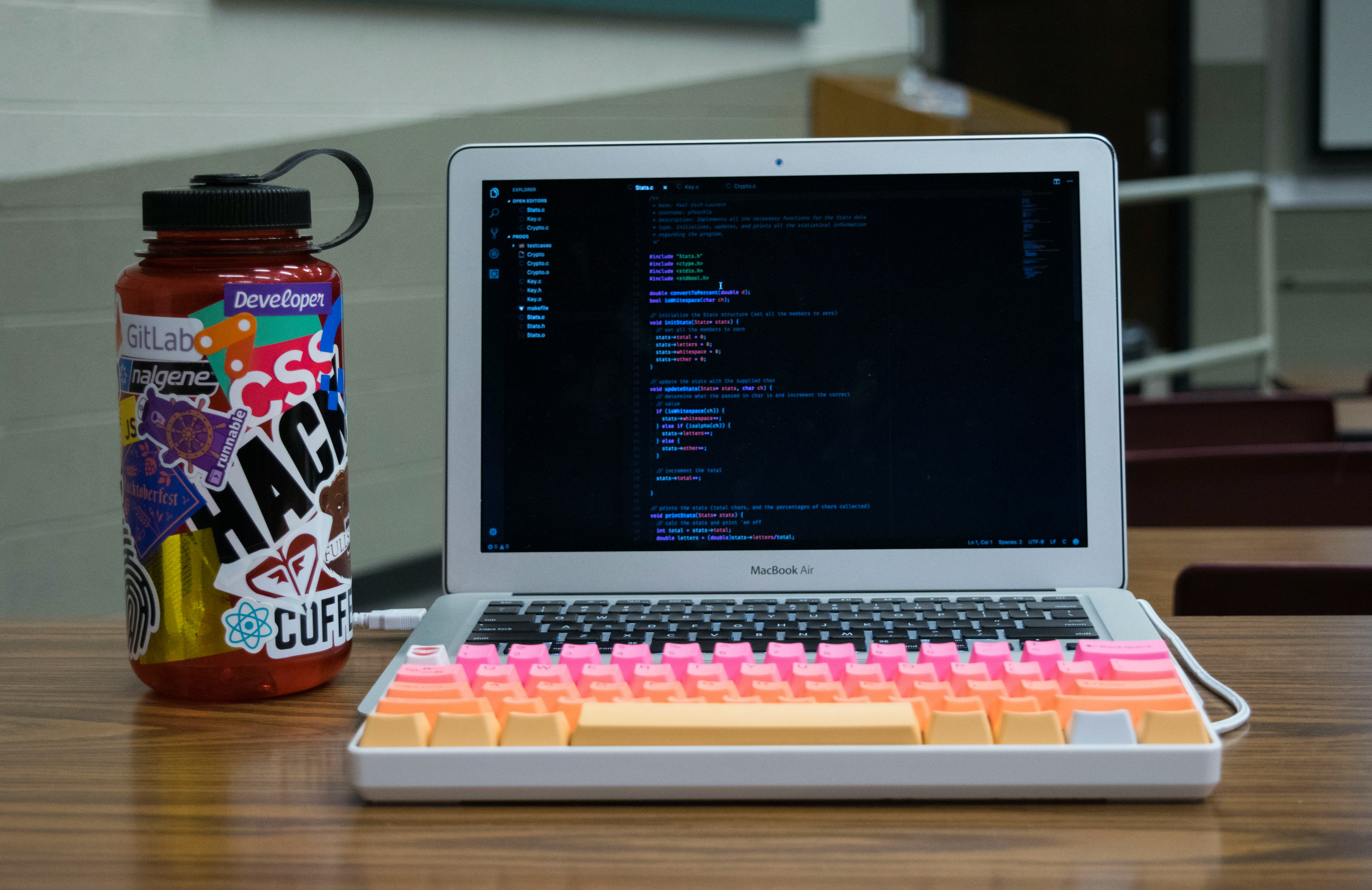 MacBook with developer stickers showing AI coding tools